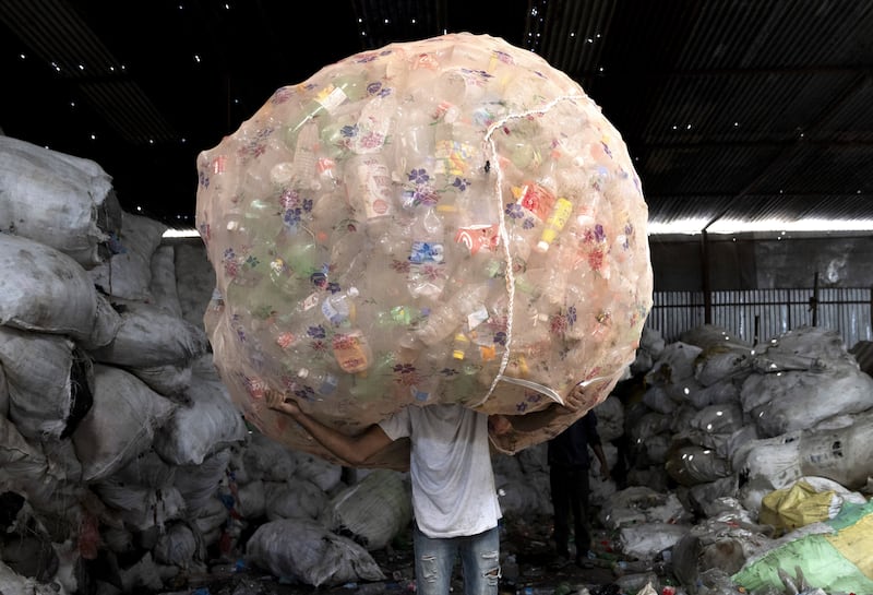 A worker carries bundles of PET bottles at a plastic waste collection company in Kathmandu, Nepal. EPA
