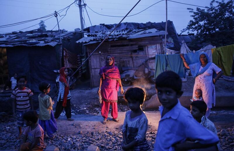 Fifty-five-year-old Subna Bi, center, poses for a picture outside her house next to the abandoned former Union Carbide Corp pesticide plant in Bhopal.