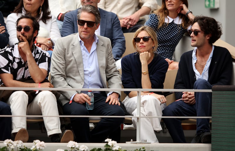 Actors Hugh Grant and Sienna Miller watch the final between Rafael Nadal and Casper Ruud at Roland Garros. Getty