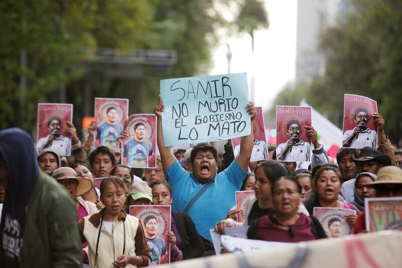A man holds up a placard reading 'Samir didn't die, the government killed him' during a protest to demand justice for Mexican activist Samir Flores Soberanes, who was gunned down by unknown assailants, in Mexico City. 2019. Reuters