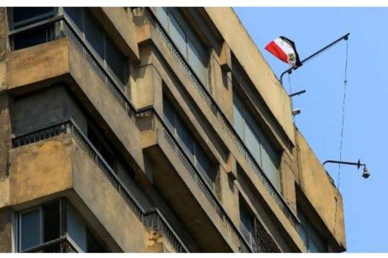 An Egyptian flag flutters over the Israeli embassy in Cairo Sunday. A protester became a hero to the Egyptians outside the embassy and many more online by hauling down the Israeli flag replacing it with an Egyptian one.