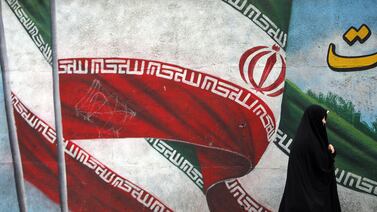 An Iranian woman walks past a painting of the national flag of Iran in Tehran, Iran, 02 May 2024. EPA