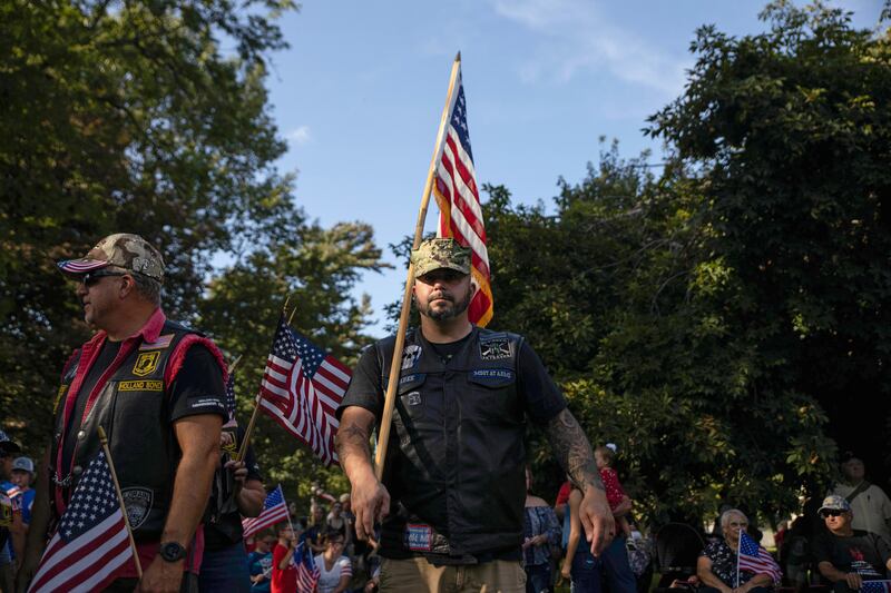 Community members carry flags at the vigil. Reuters