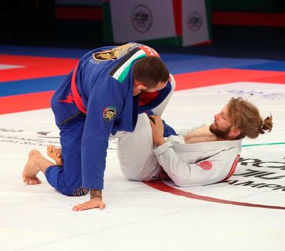 Adam Wardzinski in white gets into a guard position against Renato Cardoso in the black belt 94kg final in the 12th Abu Dhabi World Professional Jiu-Jitsu Championship at the Jiu-Jitsu Arena. Courtesy UAEJJF