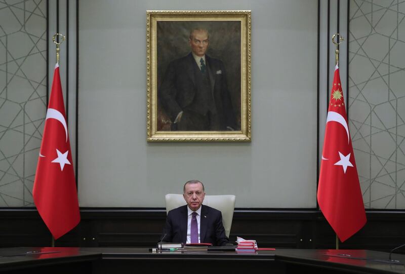 Turkey's President Recep Tayyip Erdogan, backdropped by a painting depicting modern Turkey's founder Mustafa Kemal Ataturk, chairs his government's cabinet in Ankara, Turkey, Monday, April 26, 2021. Erdogan said he was "highly saddened" by U.S. President Joe Biden's decision to mark as genocide the mass deportations and massacres of Armenians in the early 20th century Ottoman Empire, calling it baseless and unjust. (Turkish Presidency via AP)