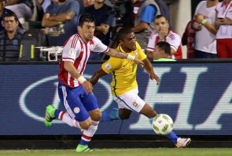Brazil’s Douglas Costa (R) and Paraguay’s Edgar Benitez vie for the ball during their Russia 2018 Fifa World Cup South American Qualifiers’ football match in Asuncion, on March 29, 2016. AFP PHOTO / NORBERTO DUARTE