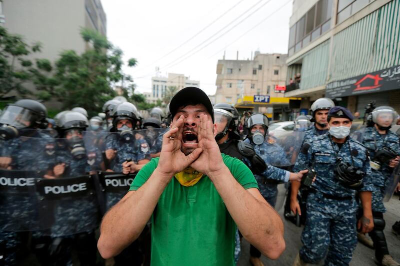 A protester chants slogans as he is flanked by Lebanese police during an anti-US demonstration outside the American embassy in Awkar, north-east of the capital Beirut. AFP