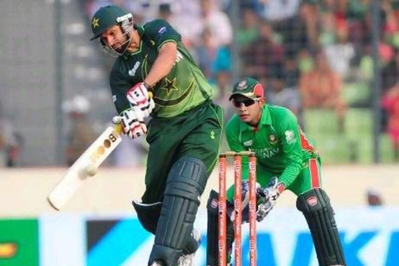 Pakistan's batsman Shahid Afridi, left, plays a shot as the Bangladeshi cricket captain Mushfiqur Rahim (R) looks during the one day international (ODI) Asia Cup cricket final match between Bangladesh and Pakistan at the Sher-e-Bangla National Cricket Stadium in Dhaka on March 22, 2012. AFP PHOTO/