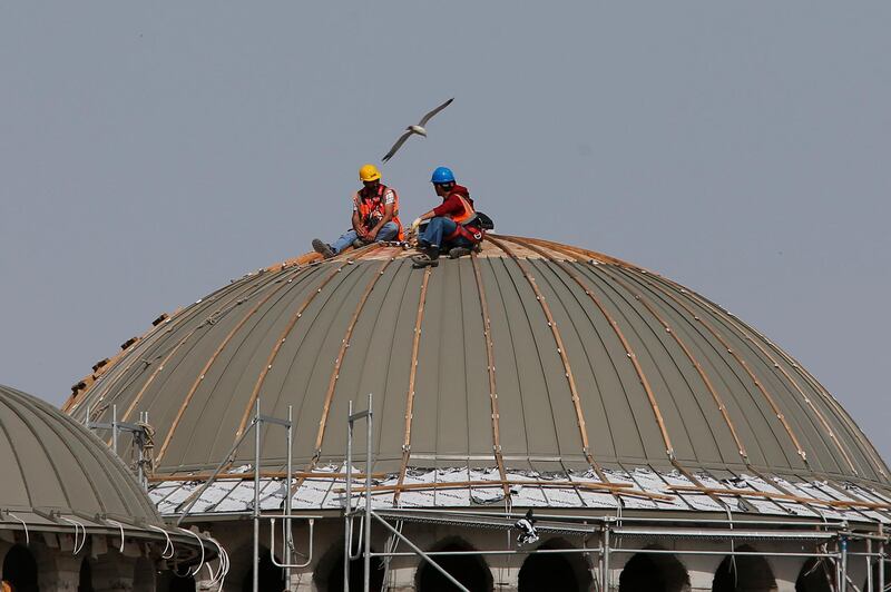 Workers take a break on the dome of a mosque under construction in Istanbul, Monday. The mosque in the historic Taksim square of central Istanbul which began to take shape in 2017, is expected to open for prayer later this year. AP Photo