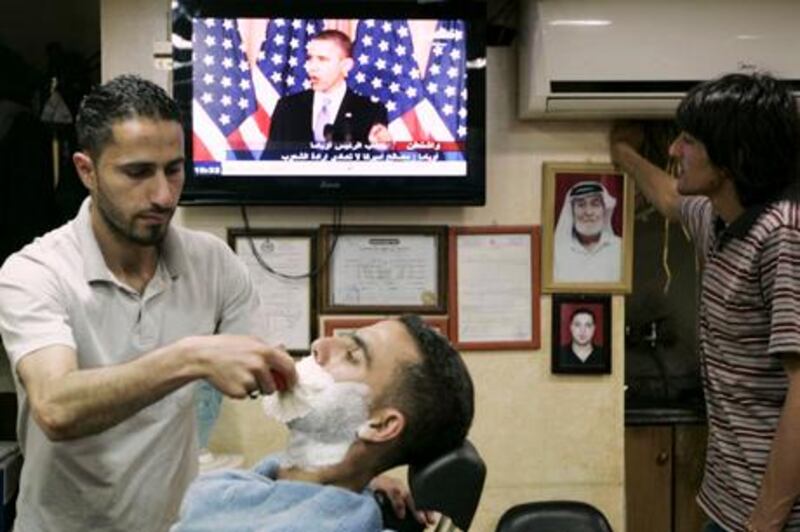 A Palestinian barber shaves a customer during a speech by U.S. President Barack Obama, in the West Bank city of Ramallah, Thursday, May 19, 2011. Trying to advance debate in the explosive Middle East, President Barack Obama on Thursday endorsed a key Palestinian demand for the borders of its future state and prodded Israel to accept that it can never have a truly peaceful nation that is based on "permanent occupation." Obama's urging that a Palestinian state be based on 1967 borders - those that existed before the Six Day War in which Israel occupied East Jerusalem, the West Bank and Gaza - was a significant shift in U.S. policy and seemed certain to anger Israel. (AP Photo/Majdi Mohammed) *** Local Caption ***  JRL119_Mideast_Israel_Palestinians_.jpg