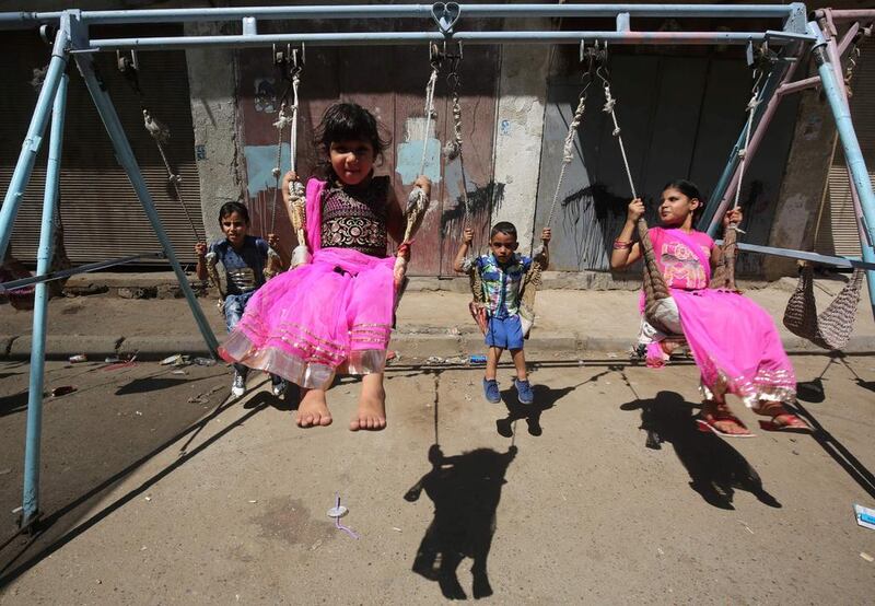 Iraqi children play on a street in the capital Baghdad on the first day of Eid al-Adha holiday.  Ahmad al-Rubaye / AFP