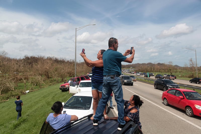 People stop on a highway near a mobile phone antenna tower (not pictured) to check for mobile phone signal, after the area was hit by Hurricane Maria, in Dorado, Puerto Rico. Alvin Baez / Reuters