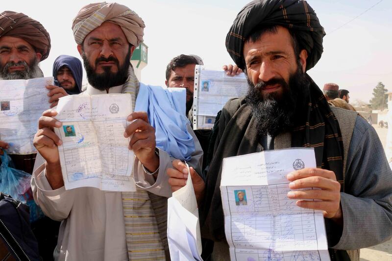 Afghans show their national IDs as they wait to cross into Afghanistan after Pakistani authorities closed the border at Chaman, Pakistan.  EPA