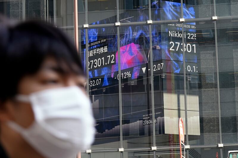 An electronic board shows share movements on Japan's Nikkei 225 index. Asian stock markets fell on Monday after Switzerland arranged the takeover of Credit Suisse. AP