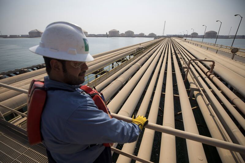 An employee looks out over oil transport pipelines on the Arabian Sea in Saudi Aramco's Ras Tanura oil refinery and oil terminal in Ras Tanura, Saudi Arabia, on Monday, Oct. 1, 2018. Saudi Arabia is seeking to transform its crude-dependent economy by developing new industries, and is pushing into petrochemicals as a way to earn more from its energy deposits. Photographer: Simon Dawson/Bloomberg