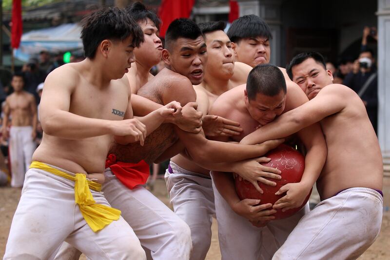 Villagers of the Hoang Mai district fight for a ball made of dried jackfruit, weighing 25kg, during the Thuy Linh village traditional ball scrambling festival, in Hanoi, Vietnam.  EPA 