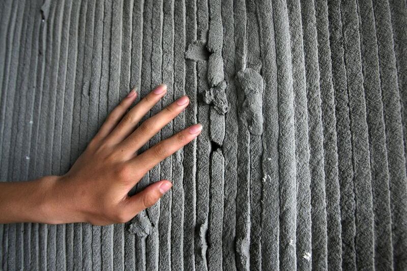 A man feels the wall of one of the 3D-printed houses at the Qingpu Park of the Shanghai Zhangjiang High-tech Industrial Development Zone in Shanghai. Weng Lei