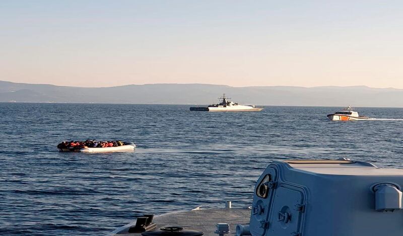 In this photo provided by the Hellenic Coast Guard and taken from a vessel shows a dinghy with migrants, left, with Turkish ships in the background, in the narrow stretch of water between the eastern Greek island of Lesbos and the Turkish coast on Friday, April 2, 2021. Greece is reporting a series of incidents with the Turkish coast guard in the narrow stretch of water between the eastern Greek island of Lesbos and the Turkish coast, at a time of generally testy relations between the two neighbors and NATO allies. The Greek coast guard said three incidents occurred Friday morning northeast of Lesbos, an island on the main migrant smuggling route from Turkey to Greece. It said two involved Turkish coast guard vessels escorting or pushing dinghies carrying migrants toward Greek territorial waters. There was no immediate reaction from Turkish authorities. Turkey and Greece have long traded accusations over the migration issue. (Hellenic Coast Guard via AP)