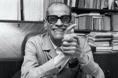 Photo prise le 13 octobre 1988 de l'écrivain égyptien Naguib Mahfouz à son bureau, au Caire, après l'annonce de sa nomination comme lauréat du Prix Nobel de Littérature. Egyptian writer Naguib Mahfuz by his desk in Cairo 13 october 1988, obviously happy about his Nobel Prize for Literature. (Photo by PETER OFTEDAL / SCANPIX SWEDEN / AFP)