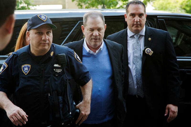 FILE- In this May 25, 2018 file photo, NYPD Detective Nicholas DiGaudio, right, escorts Harvey Weinstein into court in New York. New York prosecutors say the former lead police detective in the sexual assault investigation urged one of Weinstein's accusers to delete information from her phone before turning it over to prosecutors. On Oct. 11, prosecutors had abandoned part of their sexual assault case against Weinstein when evidence surfaced that DiGaudio instructed a witness to keep quiet when she raised doubts about another accuser's claim of sexual misconduct. (AP Photo/Mark Lennihan, File)