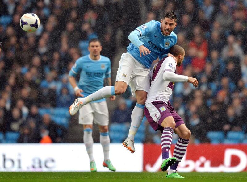 Manchester City midfielder David Silva jumps for the ball as he vies with Aston Villa defender Antonio Luna on Wednesday. Paul Ellis / AFP / May 7, 2014