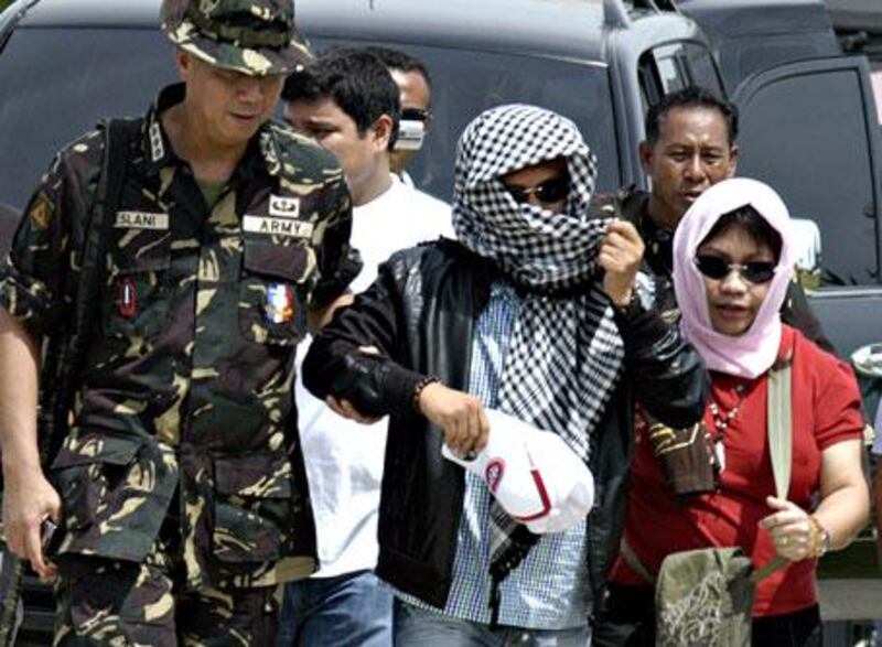 Andal Ampatuan, centre, is escorted by military personnel to a helicopter after he surrendered to authorities in Sharif Aguak, province of Maguindanao on November 26, 2009.