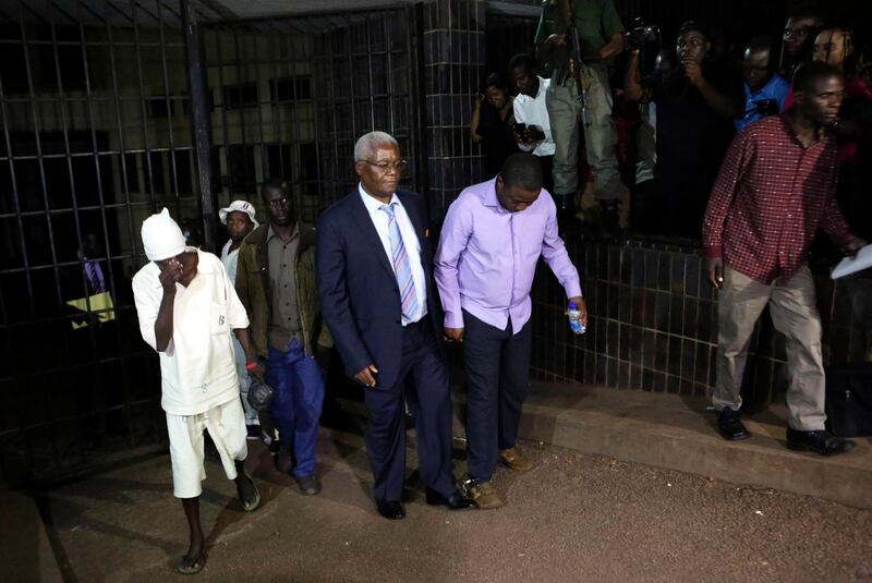 Zimbabwe's former finance minister, Ignatius Chombo, centre left, and Kudzanai Chipanga are led to a prison truck at the magistrates courts in Harare, Zimbabwe, Saturday, Nov.25, 2017. Zimbabweâ€™s ex-finance minister on Saturday testified that armed men in masks and uniforms abducted him from his home during the military operation leading to the ouster of longtime leader Robert Mugabe and held him for a week in an unidentified location, fueling debate about the legality of the popular, mostly peaceful takeover by the armed forces. (AP Photo/Tsvangirayi Mukwazhi)