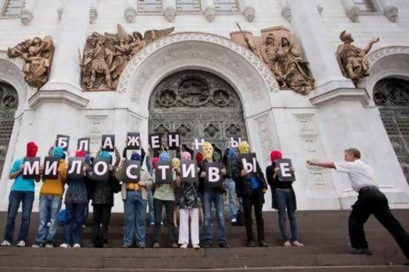Pussy Riot supporters hold letters saying, 'The merciful are blissful', as they participate in a flash mob near the Christ the Savior Cathedral in Moscow.