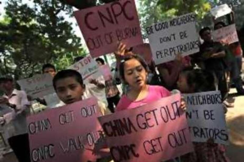 Myanmarese children and demonstrators (background) shout anti-China and Myanmar's anti-military junta slogans during a protest in New Delhi on October 28, 2009. Protestors urged the Chinese government to call for suspension of a proposed gas pipeline from Myanmar's Arakan State to China's Yunnan Province.  AFP PHOTO/ MANAN VATSYAYANA