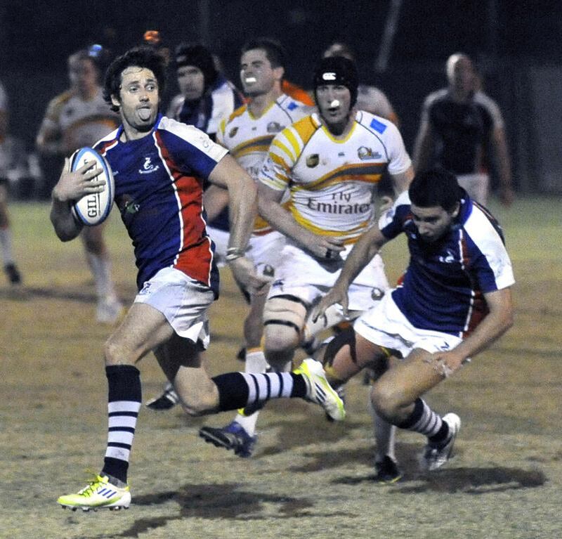 Dan Bell, left, of Jebel Ali Dragons, scores a try during their win over Dubai Hurricanes in UAE Premiership final on Friday night. Charles Crowell for The National