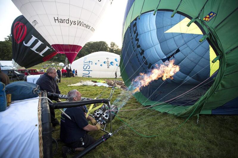 Balloonists prepare their hot air balloon for a mass ascent.