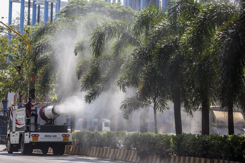 An anti-smog gun blows vapourised water into the air and on the trees to curb air pollution in Mumbai. EPA