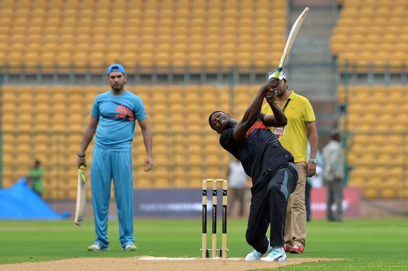 Usain Bolt, right, hits a six as Yuvraj Singh looks on during a practice session prior to the match on Tuesday, a four-over exhibition that was played at Chinnaswamy Stadium in Baglore. Majunath Kiran / AFP
