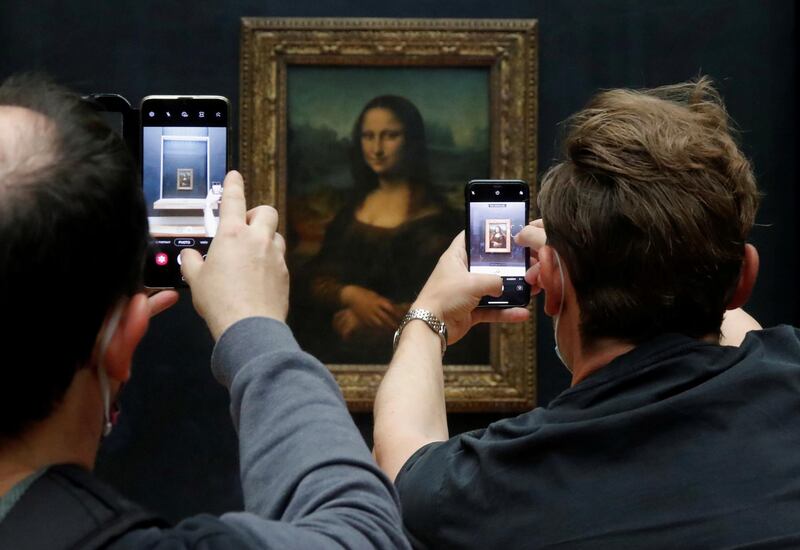 Visitors take pictures of the painting "Mona Lisa" (La Joconde) by Leonardo da Vinci at the Louvre museum in Paris as the museum reopens its doors to the public after an almost four-month closure due to the coronavirus disease (COVID-19) outbreak in France, July 6, 2020. REUTERS/Charles Platiau     TPX IMAGES OF THE DAY