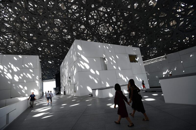 A picture taken on November 6, 2018 shows visitors inside the Louvre Abu Dhabi museum, in the Emirati capital. The museum, designed by the French architect Jean Nouvel, will celebrate the first anniversary of its official opening to the public on November 11.  / AFP / GIUSEPPE CACACE
