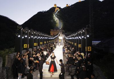 A model is assisted off the runway while wearing a dress by Fendi, at the Great Wall of China near Beijing in 2007. Reuters