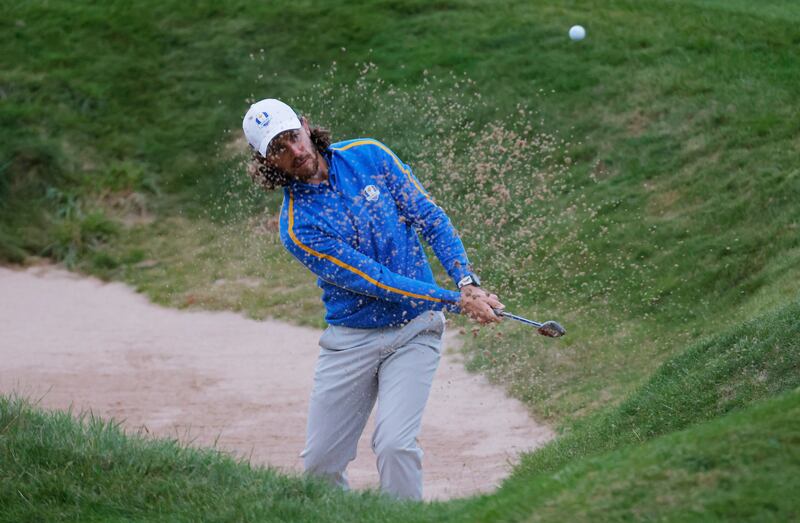 Team Europe's Tommy Fleetwood plays out from the bunker on the 18th hole. Reuters