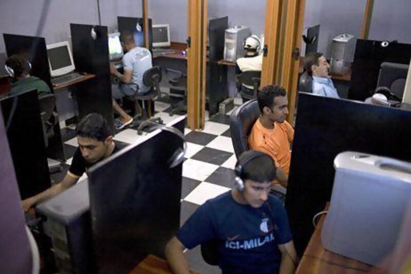Sitting in front of computer terminals, young people send and receive email at an internet cafe in central Baghdad. internet cafes have become a more popular point for communications as violence has curtailed travel inside the country. This cafe charges less than 1 USD per hour for internet use.