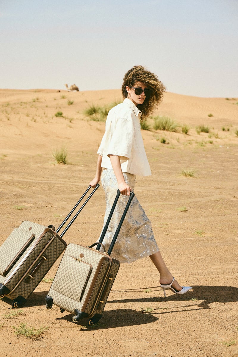 Denim shirt, Dh7,950; skirt, Dh22,400, both from Brunello Cucinelli. Shoes, Dh2,675, Malone Souliers. Sunglasses, Dh1,010, Gentle Monster. Cabin suitcase, Dh12,688; and medium suitcase, Dh14,200, both from Gucci