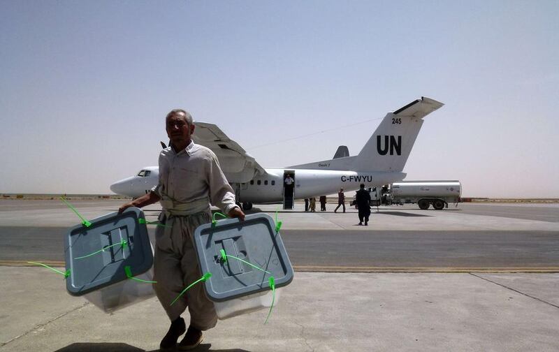 Afghan election commission workers, overseen by Nato-led Italian troops, unload ballot boxes flown in on a UN aircraft from Farah province and to be sent onward to Kabul, at Herat airport on July 24, 2014. Afghanistan is undertaking a massive anti-fraud audit of its recently concluded presidential vote to avert an impasse that threatened to revive ethnic conflict as foreign forces wind down their war against the Taliban. AFP Photo