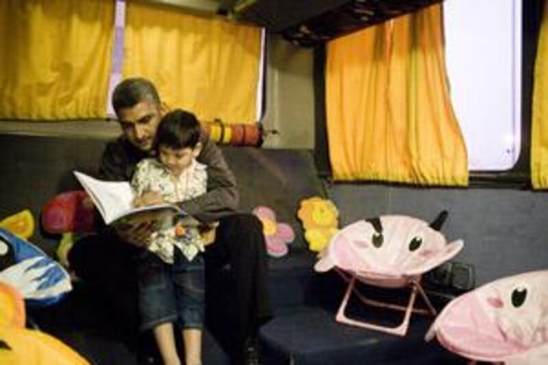 S Yawer Abbas and his four-year-old son, Behjat, read in the Kitab Bus in Al Ain.
