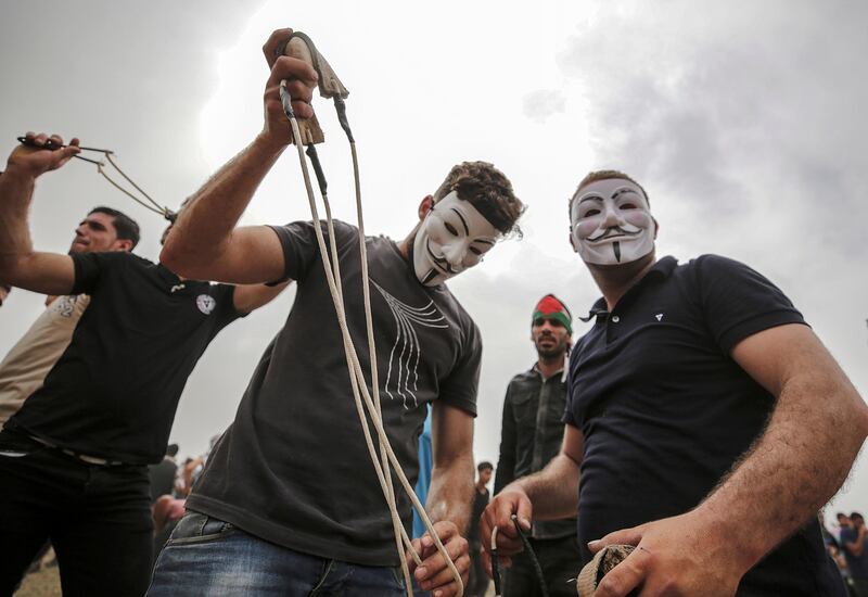 Palestinians protesters prepare their slingshots during clashes after Friday protests near the border with Israel in eastern Gaza City. Mohammed Saber / EPA