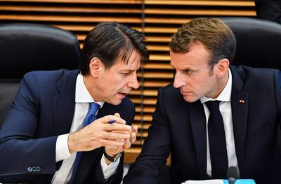 French President Emmanuel Macron (R) speaks with Italian Prime Minister Giuseppe Conte during a round table meeting at an informal EU summit on migration at EU headquarters in Brussels on June 24, 2018. EU leaders headed to Brussels for emergency talks over migration as Italy's new populist cabinet turned away another rescue ship, vowing no longer to shoulder Europe's migrant burden. / AFP / Geert Vanden Wijngaert
