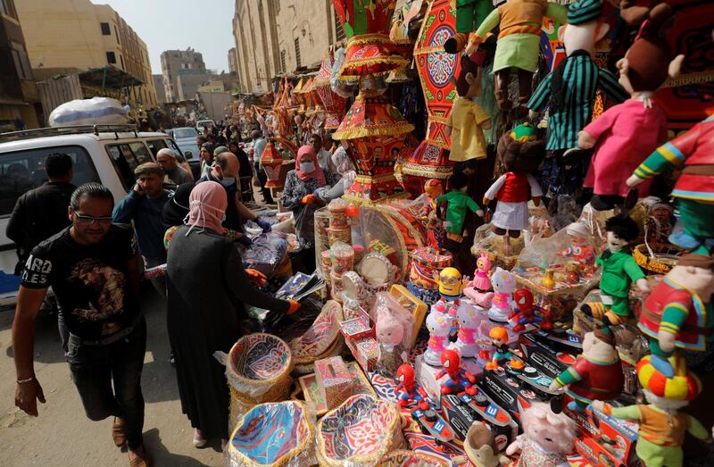 People wearing protective face masks shop traditional Ramadan products which are displayed for sale at Al Khayamia street in old Cairo. Reuters