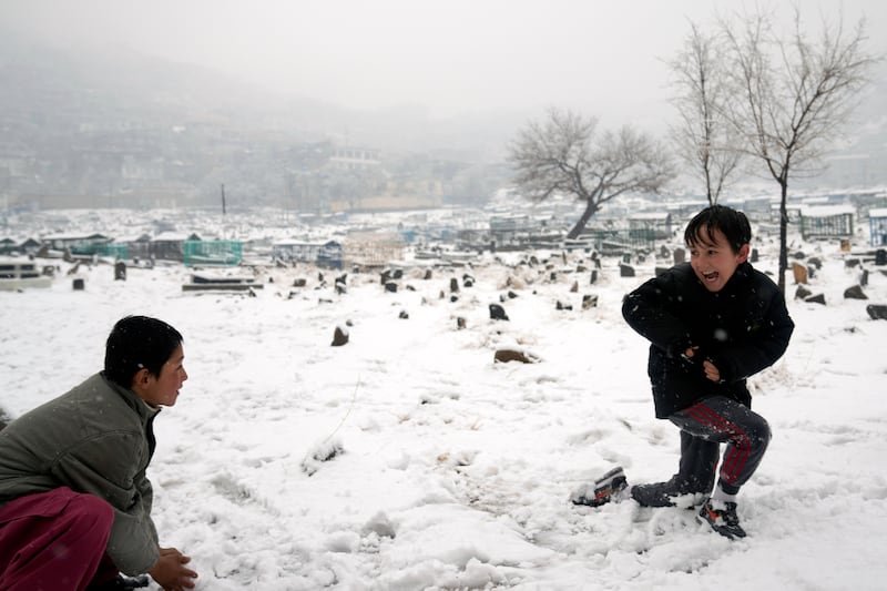 Boys play with snow in a cemetery in Kabul. AP