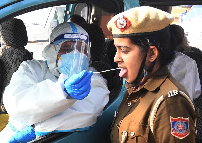 A health worker collects swab sample of a policewoman at the site of farmers protest, at the New Delhi - Haryana, Sindhu border, India. EPA