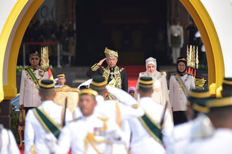 Malaysia's new King Sultan Abdullah and Queen Tunku Azizah, center right, inspect the royal guard. Malaysia Information Ministry via AP