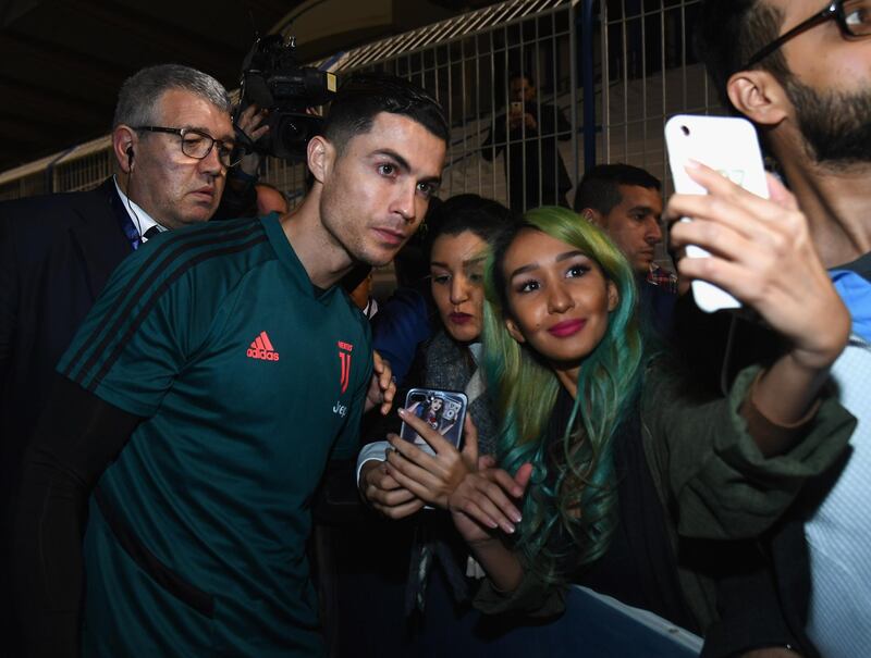 RIYADH, SAUDI ARABIA - DECEMBER 21:  Cristiano Ronaldo of Juventus signing autographs and taking selfie before the training session on December 22, 2019 in Riyadh, Saudi Arabia.  (Photo by Claudio Villa/Getty Images for Lega Serie A)