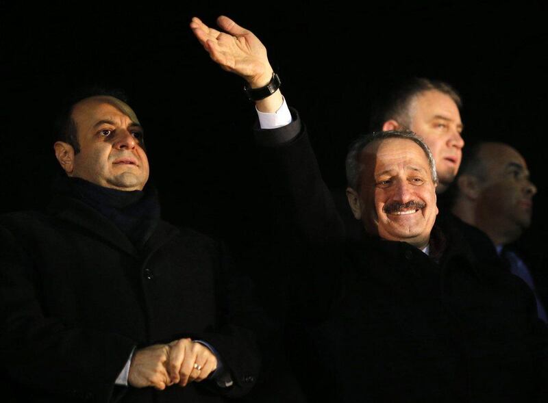 Turkey’s European Affairs Minister Egemen Bagis, left, and Economy Minister Zafer Caglayan greet their supporters at Esenboga Airport in Ankara on  December 24, 2013. Caglayan was one of three Turkish ministers who resigned Wednesday after their sons were arrested in a corruption investigation that has pitted the government against the judiciary and rattled foreign investors.  Photo: Umit Bektas / Reuters