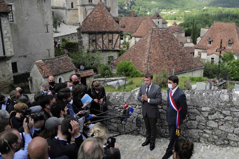 French President Emmanuel Macron (L) and mayor Gerard Miquel give a press conference  during a visit in Saint-Cirq-Lapopie, near Cahors, southwestern France, on June 2, 2021. Macron is on a two-day visit in the Lot region to promote French touristical heritage and to highlight the importance of tourism, which has been hardly hit by the pandemic, ahead of the summer holidays. / AFP / POOL / Lionel BONAVENTURE
